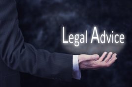 A businessmans hand holding the words, Legal Advice.